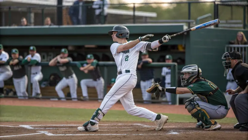 College baseball player at bat during competitive game with catcher and umpire